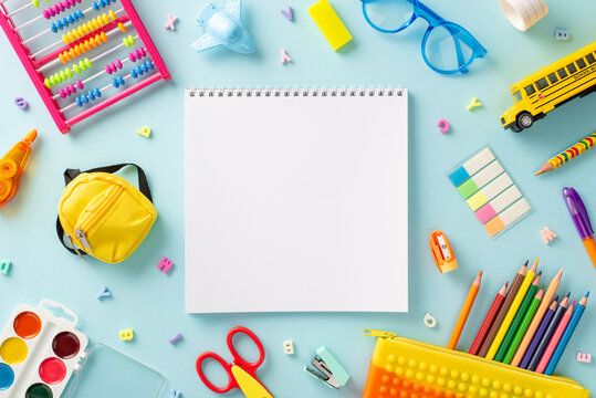 Immerse in the world of fun education for small kids with this top view image: vibrant assortment of colorful school supplies on tranquil pastel blue background, ready for text or promotional content