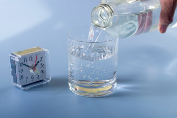 Detail of person filling glass of water. hydration concept