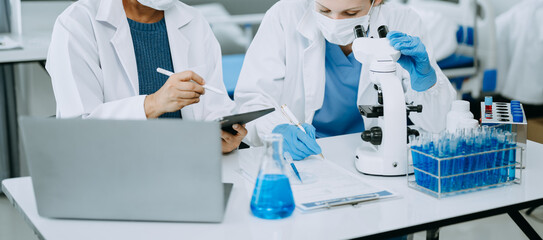 Scientist team meeting and writing analysis results in the laboratory study and analyze scientific...