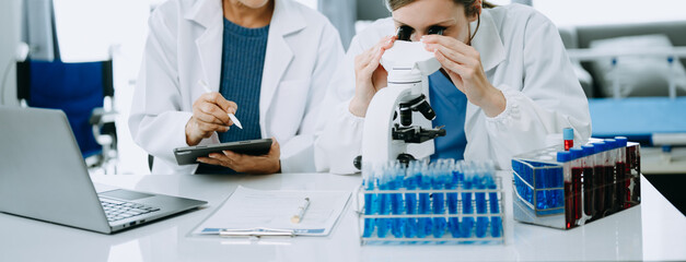 Scientist team meeting and writing analysis results in the laboratory study and analyze scientific sample.