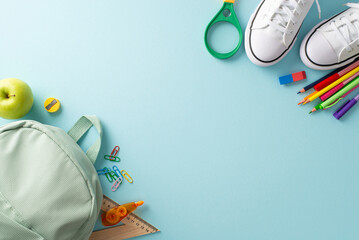 Academic preparation theme. Top-down shot showcasing backpack, sneakers and various educational materials on pastel blue background, offering ample copy-space for text or promotional content