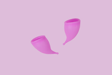 Pink reusable silicone menstrual cups on pink background. Concept of feminine hygiene, gynecology and health