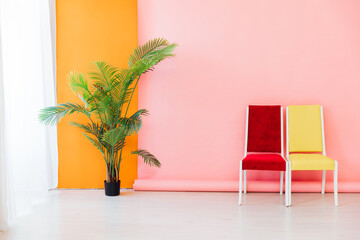 yellow and red chairs and decorative flower on a pink orange background interior