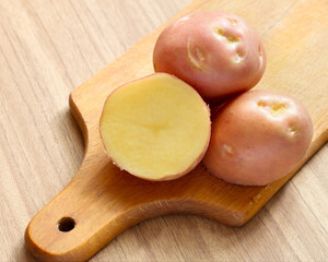 Raw potatoes on a cutting board.