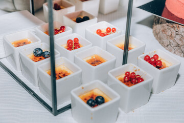 Creme brulee in small pots with berrys. Food catering on special occasions.