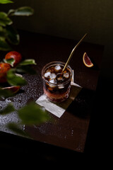 Bumble iced coffee in a glass on a dark background - trendy summer cold drink. The ingredients of a refreshing cocktail lie in layers - sweet syrup, orange juice and espresso. Bar menu.