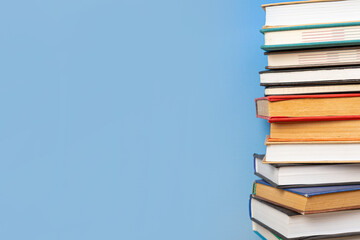 Stack of books in the colored cover lay on blue backround. Education learning concept
