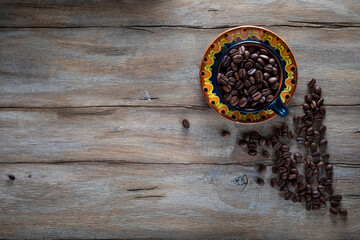 Roasted coffee beans in colored ceramic cup