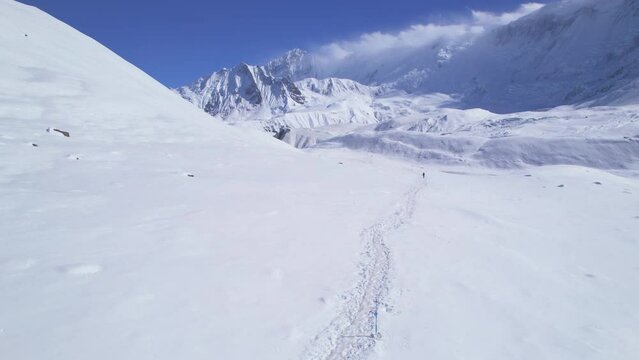 Aerial backwards viewpoint male trekker solo trek. Famous way Tilicho lake trail in Nepal, Manang district. Himalayas mountains trekking exploring mountains range concept.
