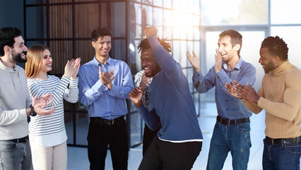 happy excited millennial employees shouting for joy, raising hands for emotional high fives.