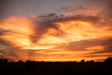 Glowing gold, orange-red, cloudy sky at sunset. Wallpaper concept.