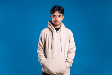 A man wearing a hoodie looks at the camera with a sharp gaze