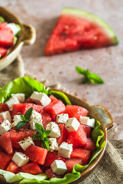 Fresh watermelon salad with feta cheese and mint on beige textured background