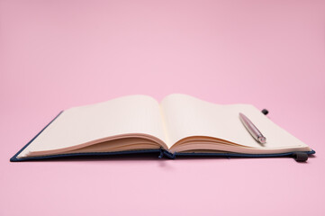 Still life with a silver pen on notebook, notepad, scratch pad with empty blank pages for dates, notes and schedules, isolated background. The concept of business, office and management organization.