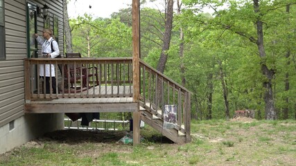 Wide shot of female doctor or nurse making a house call home visit in a rural area.
