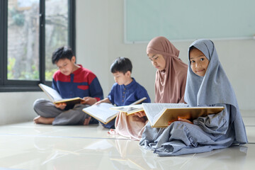 A group of children reads the holy book Quran in the mosque during the month of Ramadan. 