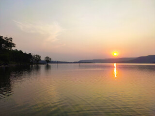 Obraz premium Calm sea with sunset sky and sun through the clouds over. Meditation ocean and sky background. Tranquil seascape. Horizon over the water.