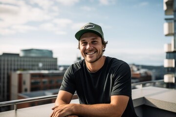 Sports portrait photography of a happy boy in his 30s wearing a cool cap against a rooftop terrace background. With generative AI technology - obrazy, fototapety, plakaty