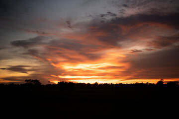 Glowing gold, orange-red, cloudy sky at sunset. Wallpaper concept.