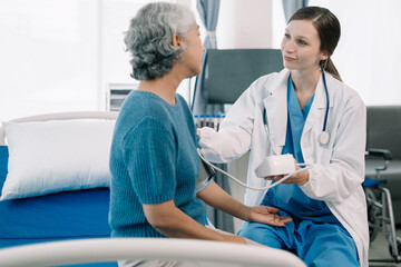 Obraz premium Female doctor having blood pressure test elderly woman at the clinic in the morning.