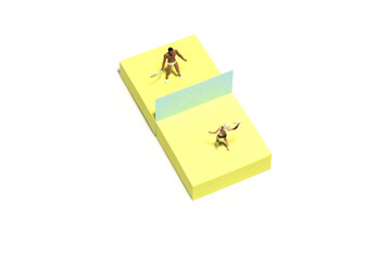 Creative miniature people toy figure photography. Sticky notes installation. A couple, men and girl playing air badminton game at beach. Isolated on white background