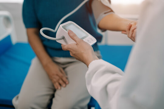 Female doctor having blood pressure test elderly woman at the clinic in the morning.