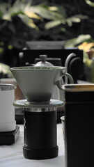 coffee dripper pot in hand. Barista drips coffee with kettle and traditional dripper. Aroma blended black coffee handmade in coffee shop with nature 