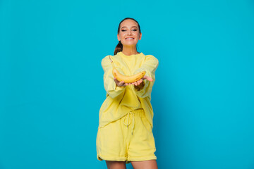 a woman gives a banana on a blue background of food