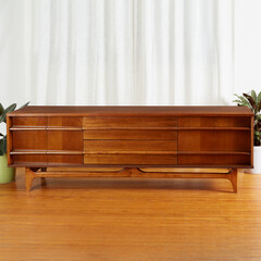 Mid-Century Modern walnut credenza. Vintage sideboard. Classic wooden furniture. Interior view before long white curtains.