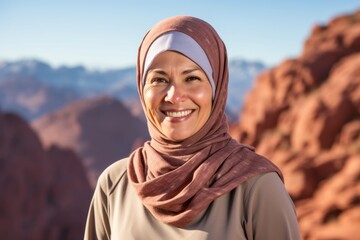 Environmental portrait photography of a glad mature woman wearing hijab against a scenic mountain overlook background. With generative AI technology