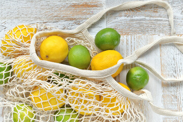 Bright yellow lemons & green limes in an Eco-friendly, low waste, reusable string bag tote