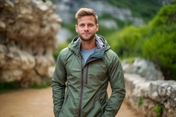 Environmental portrait photography of a satisfied boy in his 30s wearing a lightweight windbreaker against a serene rock garden background. With generative AI technology