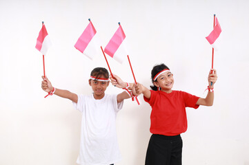 Fototapeta premium Two young girls celebrating Indonesia independence day on 17 august. Indoor. Isolated on white