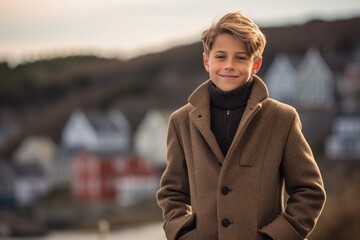 Fototapeta premium Editorial portrait photography of a happy mature boy wearing a cozy winter coat against a scenic coastal village background. With generative AI technology