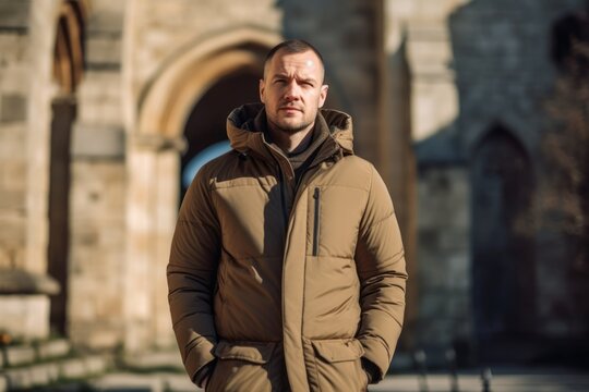 Urban fashion portrait photography of a glad mature boy wearing a warm parka against a peaceful monastery background. With generative AI technology