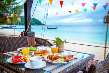 Table with breakfast on the beach. Summer vacation at a luxurious resort with a beautiful view of...