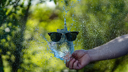 explodierender Wasserballon mit einer Sonnenbrille (experimentelles Bild)