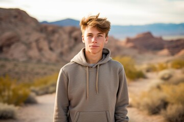 Environmental portrait photography of a glad mature boy wearing a stylish hoodie against a picturesque desert oasis background. With generative AI technology