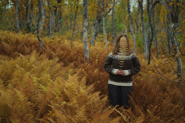 Caucasian woman standing amongst a dead yellow ferns