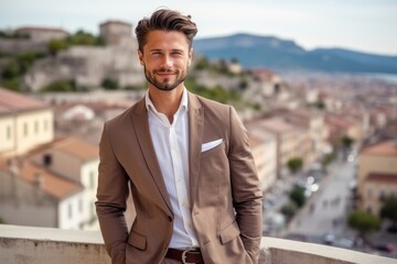 Medium shot portrait photography of a satisfied boy in his 30s wearing a classic blazer against a picturesque old town background. With generative AI technology