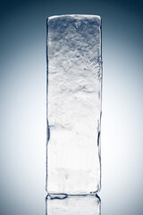 Crystal clear frosty textured natural ice block on plain background on the reflective surface.