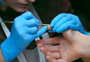Woman manicurist hands removing cuticles from clients nails using cuticle pusher - obrazy, fototapety, plakaty