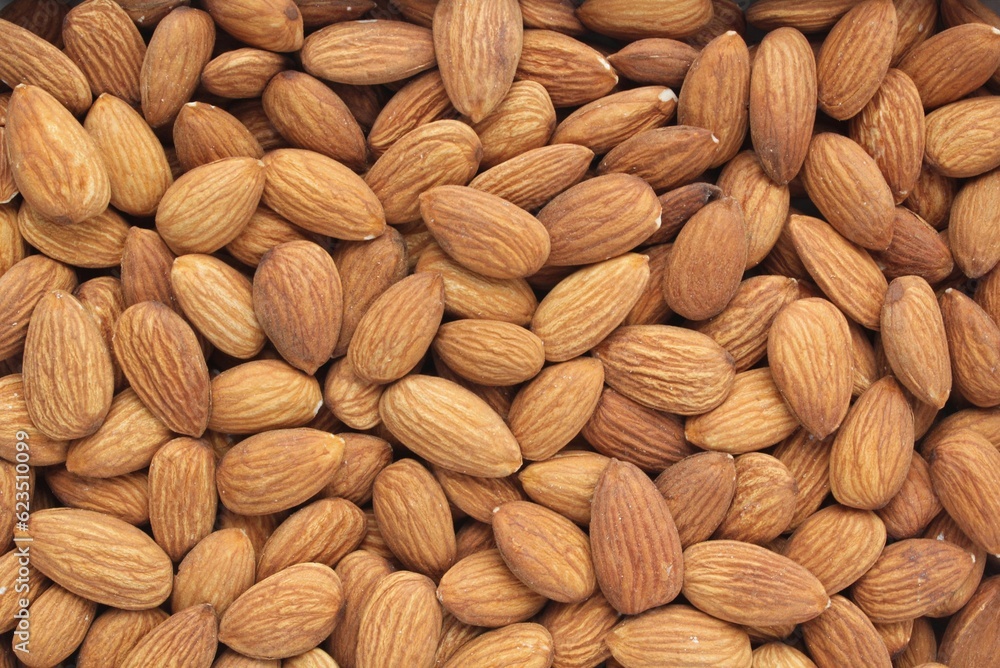 Wall mural pile of almond seeds close-up as background. pile of apricot kernel peeled. healthy eating diet, nut