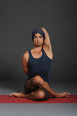 Fototapeta na wymiar Man doing yoga in photo studio on isolated grey background.