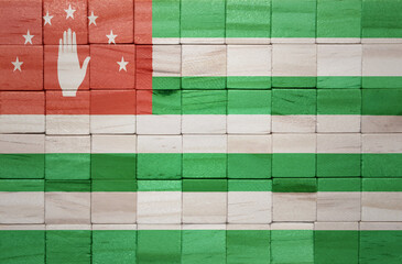 colorful painted big national flag of abkhazia on a wooden cubes texture.