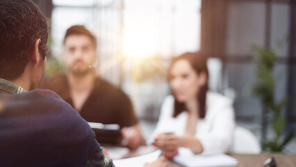 business people sitting at the table talking back view