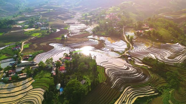 Aerial view of the water season makes the terraced fields of Y Ty commune, Lao Cai province, Vietnam appear with brown soil blending with the beautiful sky.