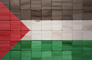 colorful painted big national flag of palestine on a wooden cubes texture.