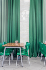 green dining chairs against the backdrop of green curtains in the dining room