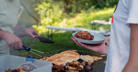 Man cooking tasty food on barbecue grill outdoors, closeup
